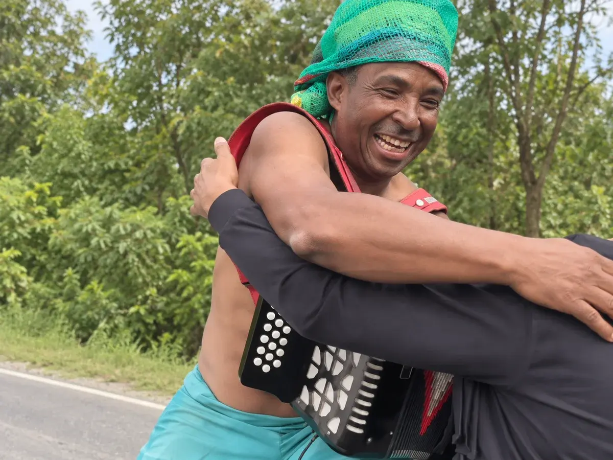 Héctor smiling as he embraces a visitor, adapted from his campaign video